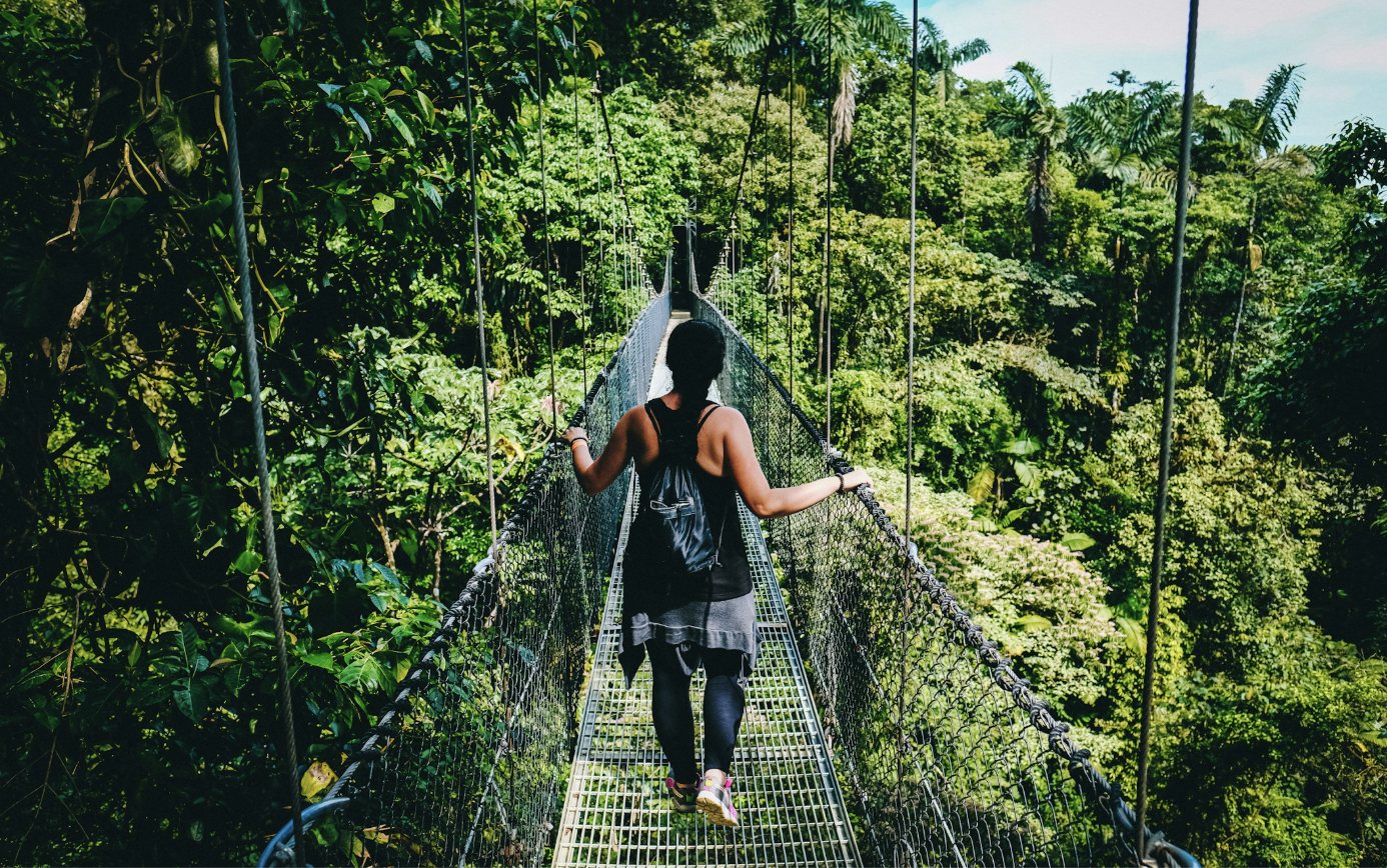 Persona caminando por un puente colgante en el bosque de Costa Rica